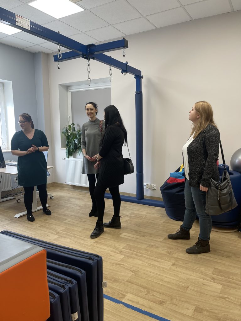 Na zdjęciu widać uśmiechniętą Panią Dyrektor Annę Szałast oraz pracowników MOPR Chełm oraz Koordynatora Punktu Panią Justynę Syroka w Sali terapii SI.