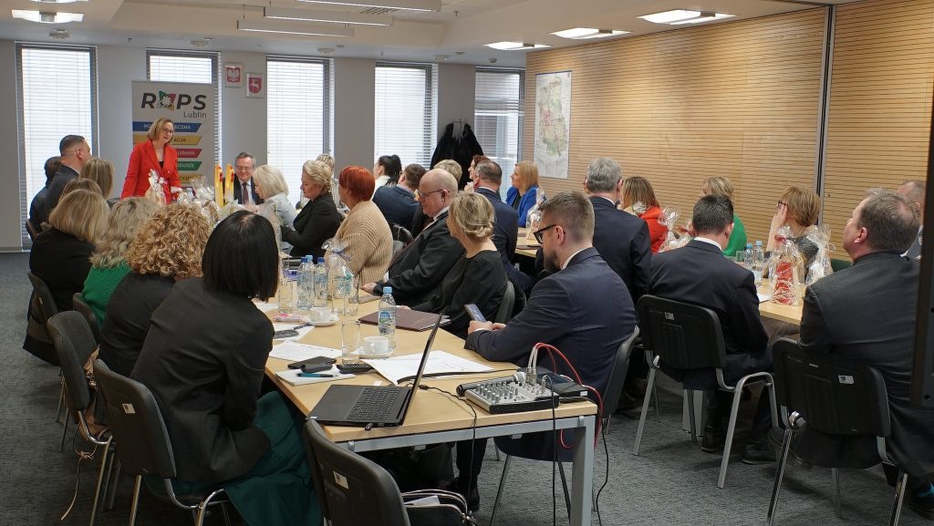 Członkowie Komitetu siedzą przy stole, Pani Dyrektor Małgorzata Romanko wygłasza przemówienie