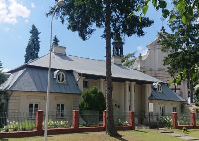 Fotografia przedstawia wejście do budynku ZAZ Lublin oraz pobliski kościół